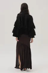 Cárdigan de tejido de punto negro con lurex de colores, detalles calados, trenzas tejidas y flecos en mangas y espalda.