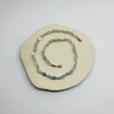 Collar de cuentas irregulares de aguamarina y piedra de la luna, con terminaciones en acero hipoalergénico.