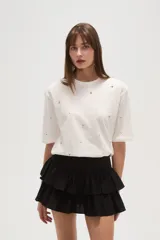 Remera blanca de algodón con tachas plateadas y cuello redondo.