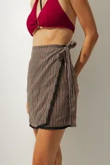 Minifalda marrón con rayas verticales negras y blancas, de corte cruzado con lazo lateral.