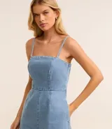 Enterito corto de jeans celeste, con breteles finos, escote cuadrado, lazo en la espalda y ruedo doblado.