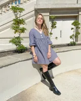 Vestido corto con estampado de cuadrillé en blanco y negro, escote en V con botones y mangas cortas con volados.