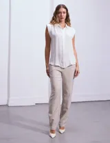 Blusa negra de gasa marca Tahari, con cuello a la base con solapa, abertura central con botones ocultos y detalle plisado en hombros.