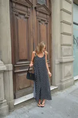 Vestido largo negro con estampado de lunares blancos, breteles finos y escote en V.