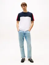 Remera Tommy Hilfiger de corte regular, confeccionada en algodón. Presenta diseño color block en blanco, azul marino y rojo en las mangas.