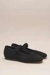 Zapato estilo Mary Jane color marrón, de cuero, con punta redondeada y tira sobre el empeine con hebilla.