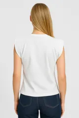 Blusa blanca de algodón, corte al cuerpo y cuello redondo.