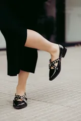 Chatitas de cuero con estampado animal print, con dos tiras cruzadas sobre el empeine y hebillas metálicas.