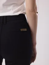 Pantalón de jean negro, tiro alto y pierna ancha con terminación desflecada.