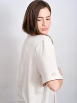 Remerón beige de corte recto y mangas cortas con terminación en color ladrillo.