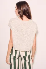 Chaleco de punto color beige con cuello redondo y mangas cortas.