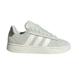 Championes Adidas Grand Court Alpha, color gris claro con las tres tiras blancas y detalles plateados en el talón. Confeccionados en gamuza y cuero sintético, con mediasuela Cloudfoam y suela de caucho.