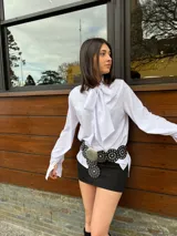 Camisa blanca de manga larga con lazo en el cuello.