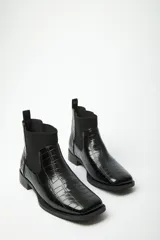 Botineta negra de símil cuero con textura de cocodrilo, recortes elásticos y taco cuadrado.