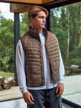 Chaleco acolchado marrón sin mangas con cuello alto y cierre lateral oculto y cremallera frontal. Bolsillos frontales y diseño plegable para fácil almacenamiento.