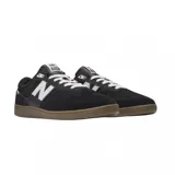 Championes New Balance NM508SBA negros con detalles en blanco y suela marrón.