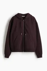 Campera con capucha color borgoña, con cierre frontal y bolsillos tipo canguro. Confeccionada en felpa con interior cepillado suave, hombros caídos, capucha forrada con cordón para ajustar y puños y bajo en punto acanalado.