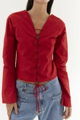 Blusa de algodón roja con mangas oxford y detalle de acordonado en la parte delantera.