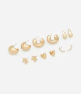 Set de aros dorados con diferentes diseños: aros tipo argolla, aros con forma de gota, aros con forma de corazón, aros con forma de flor y aros con forma de luna con incrustaciones de strass.