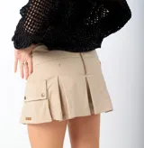 Short pollera color beige con tablas y bolsillo lateral con solapa y botón.