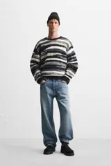 Jersey de hombre con corte relaxed, cuello redondo y manga larga. Diseño con patrón geométrico jacquard en tonos negro, gris y blanco.