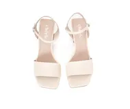 Sandalias de cuero color crema, con punta cuadrada, tira ancha sobre los dedos y pulsera al tobillo con hebilla. El tacón es cuadrado y mide 8 cm.