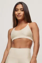 Top deportivo color beige con breteles finos y espalda deportiva.