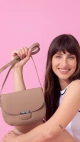 Bandolera pequeña de símil cuero color azul marino, con tapa curva y cierre metálico rectangular plateado. Incluye correa ajustable fina.