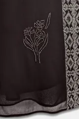 Top sin mangas color negro con escote pico profundo. Presenta bordados florales y un panel central con diseño geométrico, ambos realizados con aplicación de abalorios plateados o blancos.