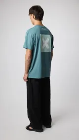Camiseta celeste con estampado en la espalda de un cuadrado con una X blanca en el centro.