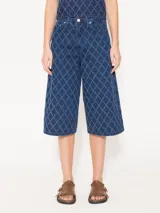 Bermuda de denim azul con diseño de rombos en relieve, corte ancho a la rodilla y tiro alto.