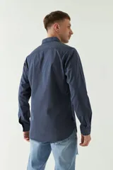 Camisa de gabardina gris con corte slim, mangas largas, cartera abotonada y dos bolsillos con solapa en el pecho.