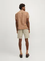 Short de jean color beige, de corte recto, con cinco bolsillos y dobladillo en el ruedo.