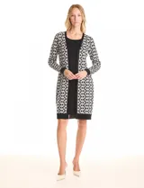 Vestido de tejido de punto marca Nina Leonard, con diseño Twofold que simula un conjunto de vestido negro liso y cárdigan largo con estampado geométrico blanco y negro. Presenta escote redondo y manga larga de corte recto.