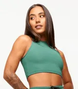 Top deportivo blanco de corte cropped, con cuello alto y logo estampado en el frente.