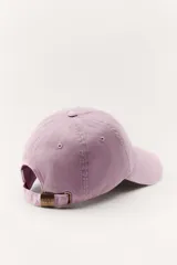 Gorra color borgoña con bordado dorado de la marca Zara, con la inscripción "Zara" y "A Coruña 1975".