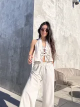 Pantalón largo de tiro alto con estampado a rayas verticales beige y blanco.