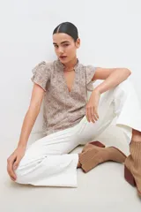 Blusa estampada con cuello mao y mangas cortas con volados.