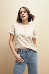Remera blanca de manga corta con estampado floral en tonos beige.