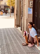 Pollera larga tejida a rayas horizontales en tonos rosa, blanco y borgoña, con detalles de crochet y tajos laterales.