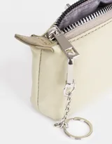 Monedero color verde claro de tela deportiva con solapa con broche con botón, cierre superior con mosquetón y tag en relieve.
