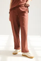 Pantalón de lino color ladrillo, de corte recto y tiro medio, con bolsillos laterales y traseros.