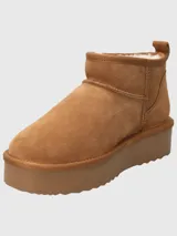 Botas cortas color marrón claro, con interior de piel sintética, plataforma y suela de goma.