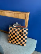 Bolso tote de cuero trenzado a mano, forrado por dentro. Presenta un patrón de cuadros grandes en tonos marrón oscuro y celeste/azul claro.