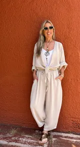 Pantalón de corte amplio color beige, con cintura elástica y lazo ajustable.