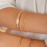 Pulsera rígida dorada con textura satinada y otra con textura martillada.