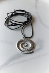 Collar con dije plateado en forma de espiral y cordón negro encerado.