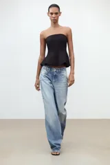 Top negro palabra de honor con peplum, confeccionado en tejido elástico con forro interior y cierre de cremallera oculta en la costura.