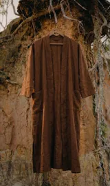 Kimono largo midi de color marrón oscuro, con mangas amplias y calce relajado. Presenta cuello tipo kimono y bolsillos frontales.
