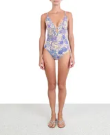 Bañador entero con diseño floral en tonos lilas y azul, con escote en V y detalle de agujero central.
